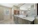 Elegant bathroom featuring a dual sink vanity with a marble countertop and decorative mirror, plus tile flooring at 1533 Oak Way, Sarasota, FL 34232