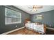 Comfortable bedroom features hardwood floors, a ceiling fan, and natural light from two windows at 1533 Oak Way, Sarasota, FL 34232