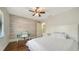 Bright bedroom with wood-look accent wall, hardwood floors, white bedding, and a modern desk at 1533 Oak Way, Sarasota, FL 34232