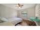 A light and airy bedroom with hardwood floors, neutral walls, ceiling fan, and a turquoise desk at 1533 Oak Way, Sarasota, FL 34232