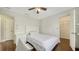 Cozy bedroom with hardwood floors, white bedding, ceiling fan, and view of a closet at 1533 Oak Way, Sarasota, FL 34232