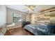 Cozy bedroom with a wood accent wall, hardwood floors, ceiling fan, and a window with natural light at 1533 Oak Way, Sarasota, FL 34232