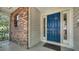 Close-up of the inviting front door and porch of the house with brick wall accents at 1533 Oak Way, Sarasota, FL 34232