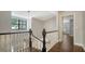 Hallway with chandelier lighting and dark-stained handrail on white decorative balusters at 1533 Oak Way, Sarasota, FL 34232