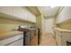 Well-organized laundry room with modern washer and dryer, built-in cabinets, sink and counter space at 1533 Oak Way, Sarasota, FL 34232