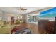 Living room with wood flooring, ceiling fan, fireplace, and sliding glass door to the lanai at 1533 Oak Way, Sarasota, FL 34232