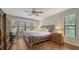 Bright main bedroom features a large window, ceiling fan, hardwood floors, and furniture at 1533 Oak Way, Sarasota, FL 34232