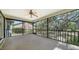 A spacious screened porch features a ceiling fan and a view of the trees and backyard at 1533 Oak Way, Sarasota, FL 34232