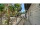 View of home's exterior from the yard featuring a small elevated porch, mature trees, and lush landscaping at 1533 Oak Way, Sarasota, FL 34232