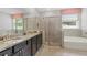 Main bathroom boasting double sinks with dark cabinets, large mirror, walk-in shower, and soaking tub at 17108 Harvest Moon Way, Bradenton, FL 34211