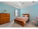 Bright bedroom with a wooden bed frame, complemented by light blue walls and neutral-toned carpet at 17108 Harvest Moon Way, Bradenton, FL 34211