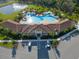Aerial view of a luxury resort style community pool with clubhouse, lounge chairs, and lush landscaping at 17108 Harvest Moon Way, Bradenton, FL 34211