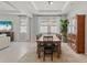 Spacious dining room with bright light, wood floors, stylish light fixture, and large wooden china cabinet at 17108 Harvest Moon Way, Bradenton, FL 34211