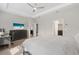 Spacious main bedroom featuring tray ceilings, wood floor, ceiling fan and access to ensuite bathroom at 17108 Harvest Moon Way, Bradenton, FL 34211