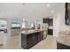 Open concept living space showcasing the kitchen island, stainless steel appliances, and a cozy living room at 17108 Harvest Moon Way, Bradenton, FL 34211