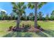 Backyard features a whimsical train set nestled between lush palm trees and manicured greenery at 17696 Northwood Pl, Lakewood Ranch, FL 34202