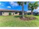Manicured backyard featuring lush lawn, screen patios, and mature palm trees at 17696 Northwood Pl, Lakewood Ranch, FL 34202