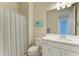 Bright bathroom features a white vanity, framed mirror, and a shower with a curtain at 17696 Northwood Pl, Lakewood Ranch, FL 34202