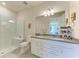 Elegant bathroom with double sinks, granite countertops, a walk-in shower, and modern fixtures at 17696 Northwood Pl, Lakewood Ranch, FL 34202