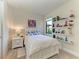 This bedroom features a cozy bed and decorative shelves by the window at 17696 Northwood Pl, Lakewood Ranch, FL 34202
