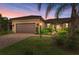 Charming single-story home featuring a tile roof, a brick driveway, and well-maintained landscaping at 17696 Northwood Pl, Lakewood Ranch, FL 34202