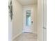 Bright hallway featuring tile flooring and a white door with decorative glass panel at 17696 Northwood Pl, Lakewood Ranch, FL 34202