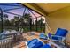 Relaxing covered patio boasts cozy furniture, brick flooring, and a picturesque view of the lush, tropical backyard at 17696 Northwood Pl, Lakewood Ranch, FL 34202