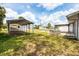 Spacious backyard with sheds, a fire pit, and a covered patio area at 18348 Yale Ave, Port Charlotte, FL 33948