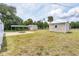 Large backyard featuring multiple sheds, a fire pit, and some trees providing shade at 18348 Yale Ave, Port Charlotte, FL 33948