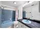 Cozy bathroom featuring blue tiling, an integrated sink and vanity with a shower and tub combo at 18348 Yale Ave, Port Charlotte, FL 33948