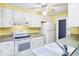 Clean kitchen featuring white appliances and cabinets, ideal for cooking at 18348 Yale Ave, Port Charlotte, FL 33948