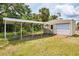 Exterior view of a backyard shed and carport with a wooden ramp to the garage door at 18348 Yale Ave, Port Charlotte, FL 33948