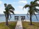 Scenic waterfront view with palm trees framing a private dock, offering serene waterfront access and relaxation at 2107 Palma Sola Blvd # 23, Bradenton, FL 34209