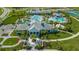 A lovely aerial view of the pool and clubhouse, surrounded by lush landscaping, palm trees, and manicured lawns at 2309 Blue Mahoe Ln, Sarasota, FL 34240