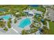 A beautiful aerial view of a community pool area, surrounded by palm trees and lush greenery near a lake at 2309 Blue Mahoe Ln, Sarasota, FL 34240