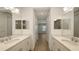 Elegant bathroom with double vanity, quartz countertops, decorative mirrors, and tiled walk-in shower at 2309 Blue Mahoe Ln, Sarasota, FL 34240