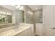 Elegant bathroom with double vanity, quartz countertops, decorative mirrors, and tiled walk-in shower at 2309 Blue Mahoe Ln, Sarasota, FL 34240