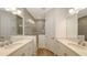 Elegant bathroom with double vanity, quartz countertops, decorative mirrors, and tiled walk-in shower at 2309 Blue Mahoe Ln, Sarasota, FL 34240