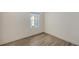 Cozy bedroom corner showcases wood-look tile flooring and natural light from the window at 2309 Blue Mahoe Ln, Sarasota, FL 34240