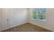 An empty bedroom features a window with outside views, wood-look tile flooring and white trim at 2309 Blue Mahoe Ln, Sarasota, FL 34240