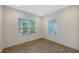 Bright, empty bedroom with two windows offering outside views, wood-look tile flooring and white trim at 2309 Blue Mahoe Ln, Sarasota, FL 34240