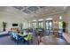 A large dining area with multiple tables and chairs, pendant lights, and large windows at 2309 Blue Mahoe Ln, Sarasota, FL 34240
