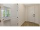 Bright entryway featuring wood-look tile flooring, white trim, and a view into another room with a window at 2309 Blue Mahoe Ln, Sarasota, FL 34240