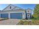 The white exterior of this two-story home is complemented by its well-maintained lawn and blue garage doors at 2309 Blue Mahoe Ln, Sarasota, FL 34240