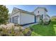 The side of a two-story home exhibits manicured landscaping, well-maintained lawn, and an appealing white exterior at 2309 Blue Mahoe Ln, Sarasota, FL 34240