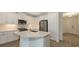 Modern kitchen with white cabinets, stainless steel appliances, and island with sink, open to the entry way at 2309 Blue Mahoe Ln, Sarasota, FL 34240