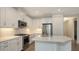 Well-lit kitchen with white cabinets, quartz countertops, stainless steel appliances and a kitchen island at 2309 Blue Mahoe Ln, Sarasota, FL 34240