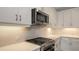 Close-up of the modern kitchen featuring stainless steel gas range and microwave at 2309 Blue Mahoe Ln, Sarasota, FL 34240