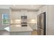 Bright kitchen features white cabinets, stainless steel appliances, and a large island with a sink at 2309 Blue Mahoe Ln, Sarasota, FL 34240