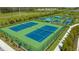 Overhead view of new community pickleball courts, featuring blue surfaces, green borders, and shelters at 2309 Blue Mahoe Ln, Sarasota, FL 34240
